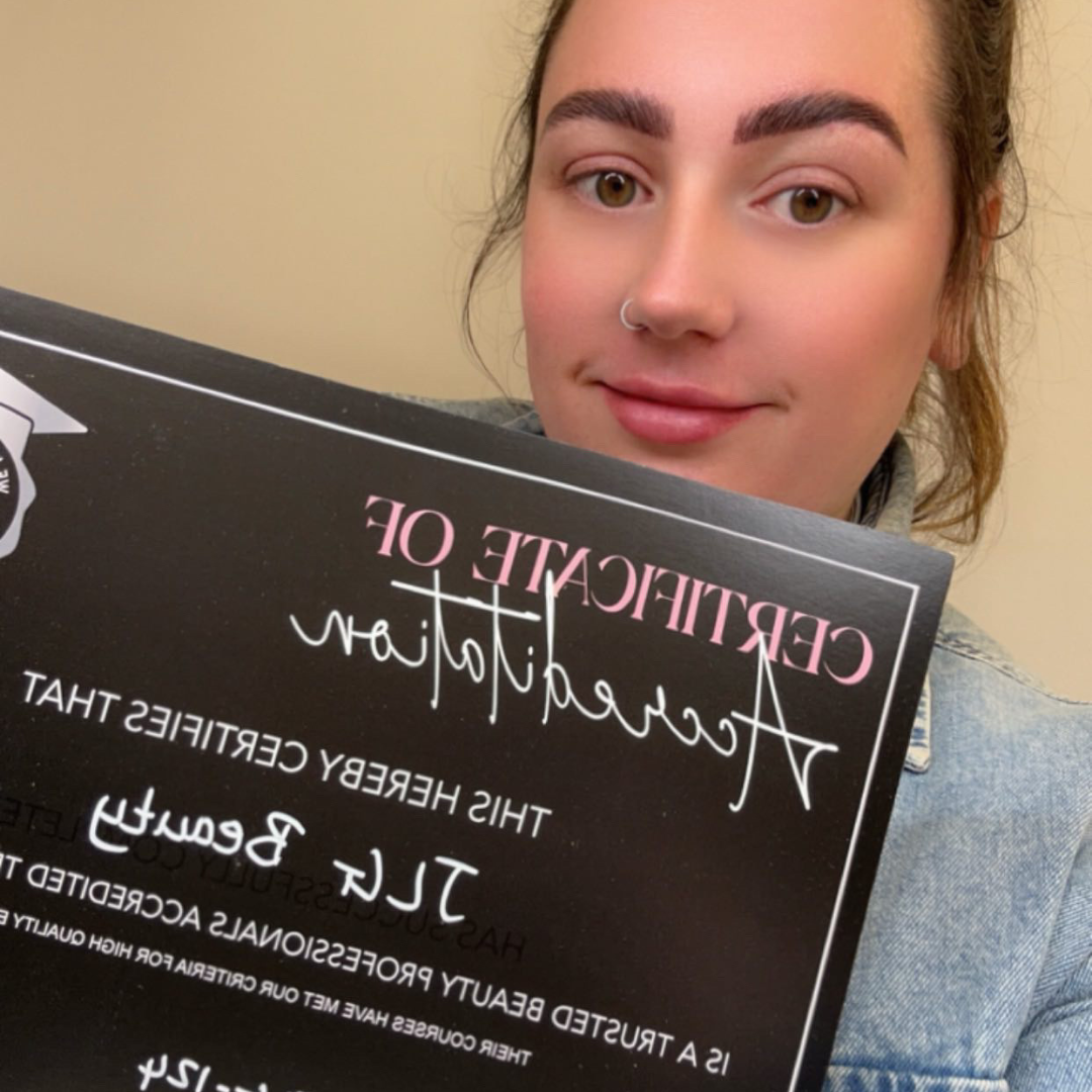 Brunette woman holding black TBP accreditation certificate